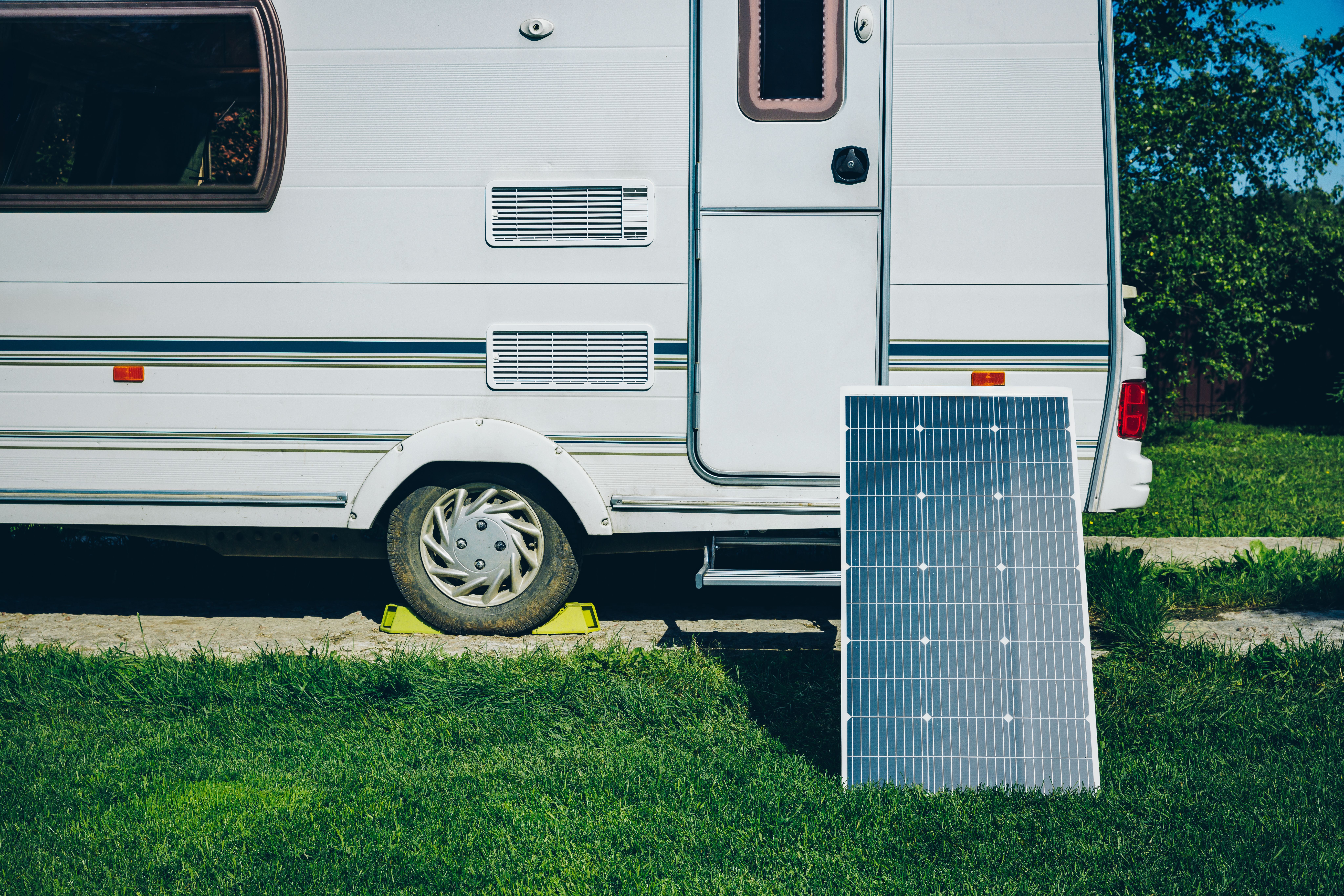 white-rv-caravan-camper-on-a-campsite-with-solar-panel